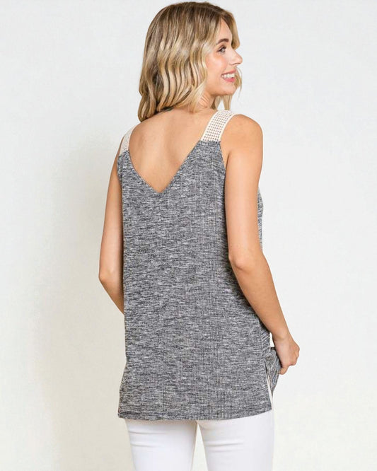 Woman wearing a gray sleeveless top with a white background