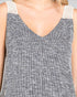 Close-up of a sleeveless top with a textured pattern and white lace trim on straps.