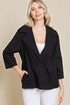 Woman wearing a black coat with a beige background