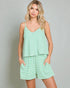 Woman wearing a green striped romper against a gray background