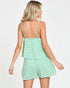 Woman wearing a mint green striped dress on a white background