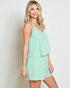 Woman wearing a mint green striped dress against a plain background