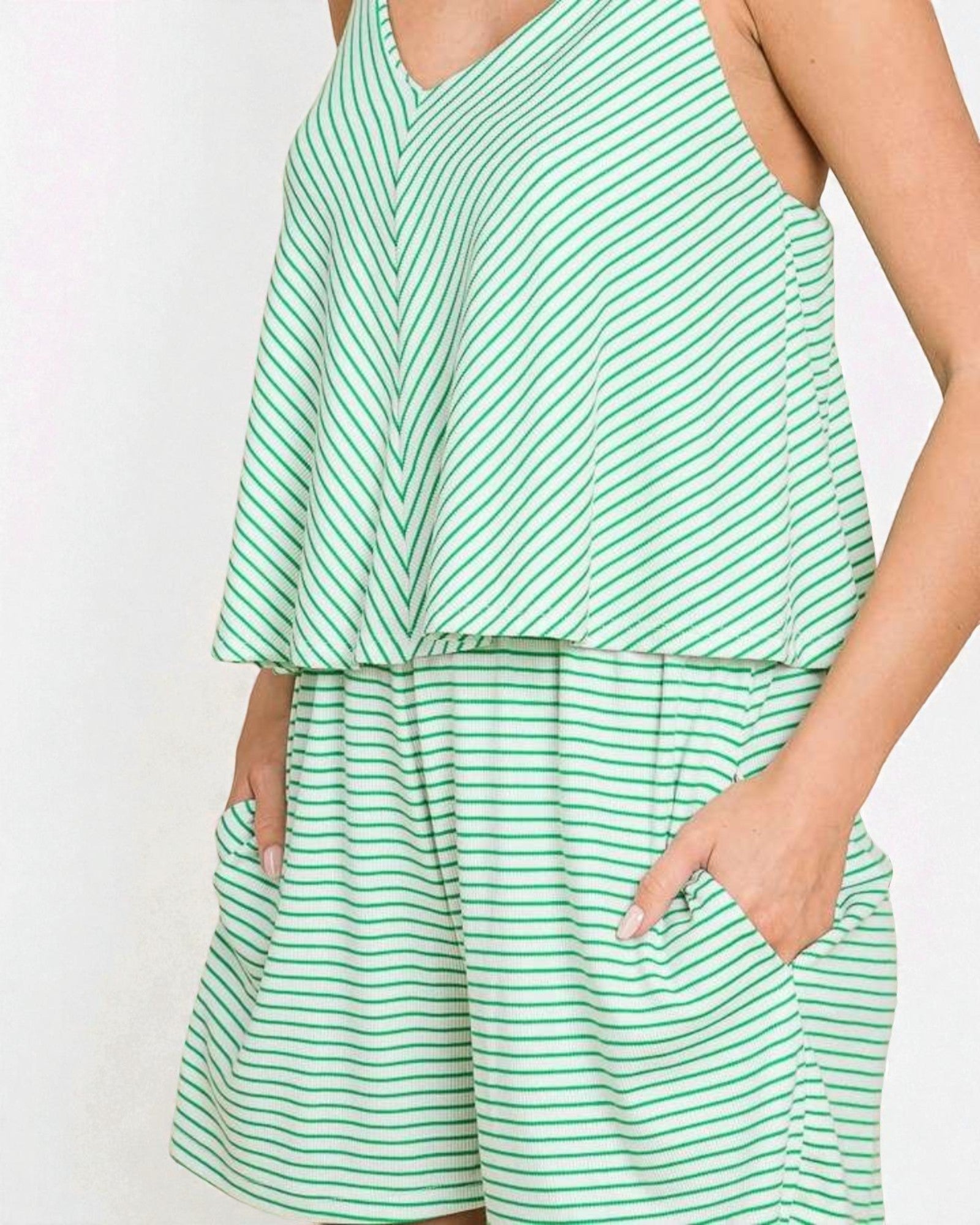 Green and white striped outfit with a top and shorts on a plain background