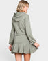 Woman wearing a green hoodie and skirt set on a white background