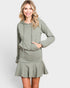 Woman wearing a green hoodie and skirt set on a white background