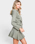 Woman wearing a green hoodie and skirt set on a white background