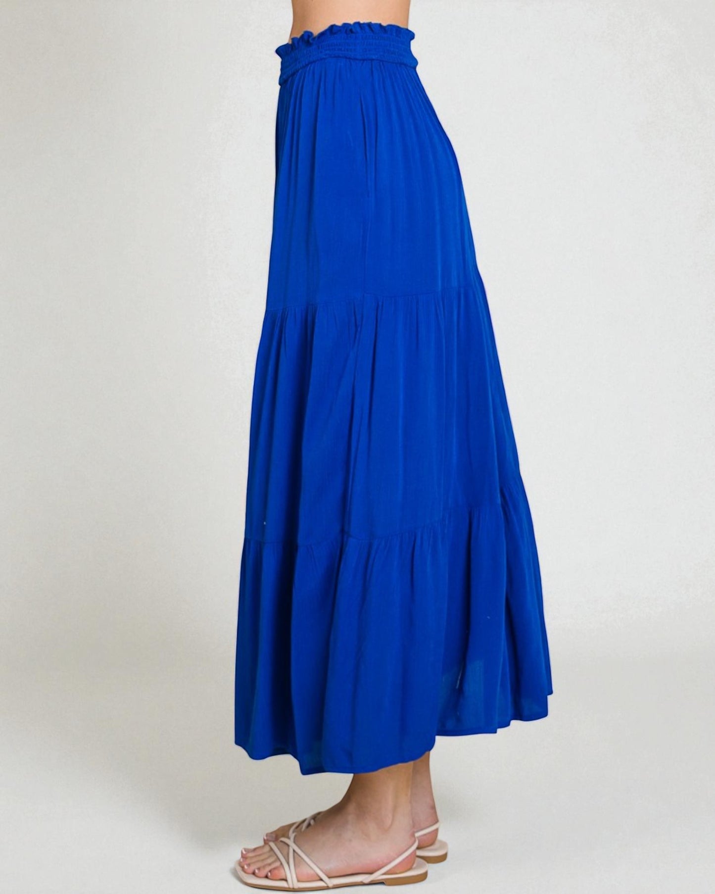 Blue skirt worn by a person on a white background