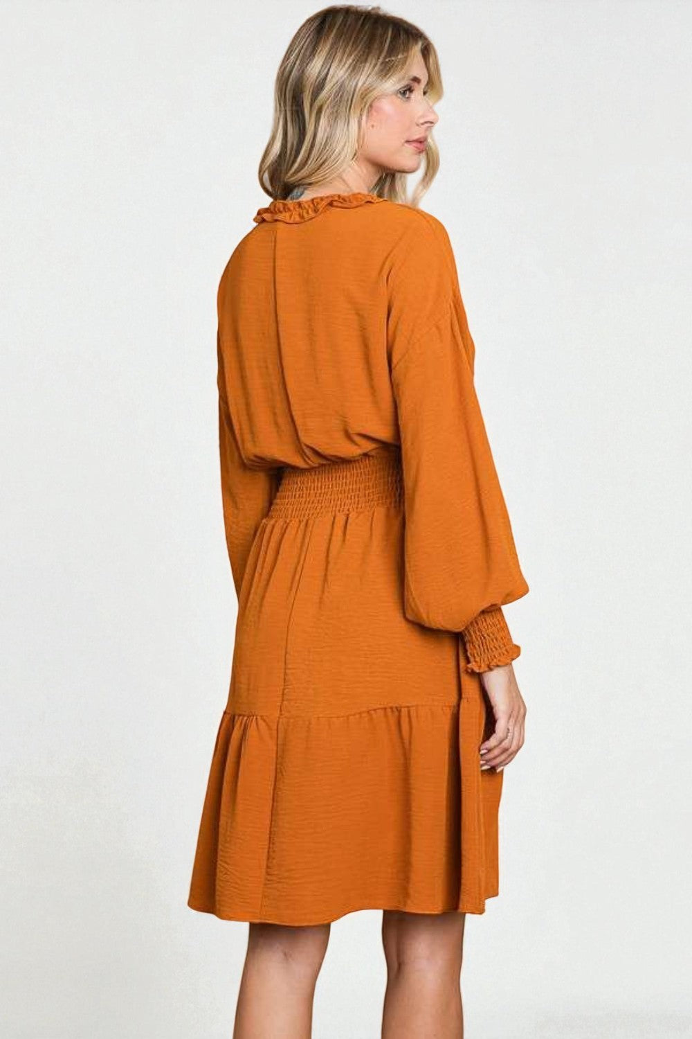 Woman wearing an orange dress on a white background