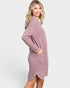 Woman wearing a pink sweater dress on a white background