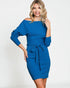 Woman wearing a blue dress with long sleeves on a white background