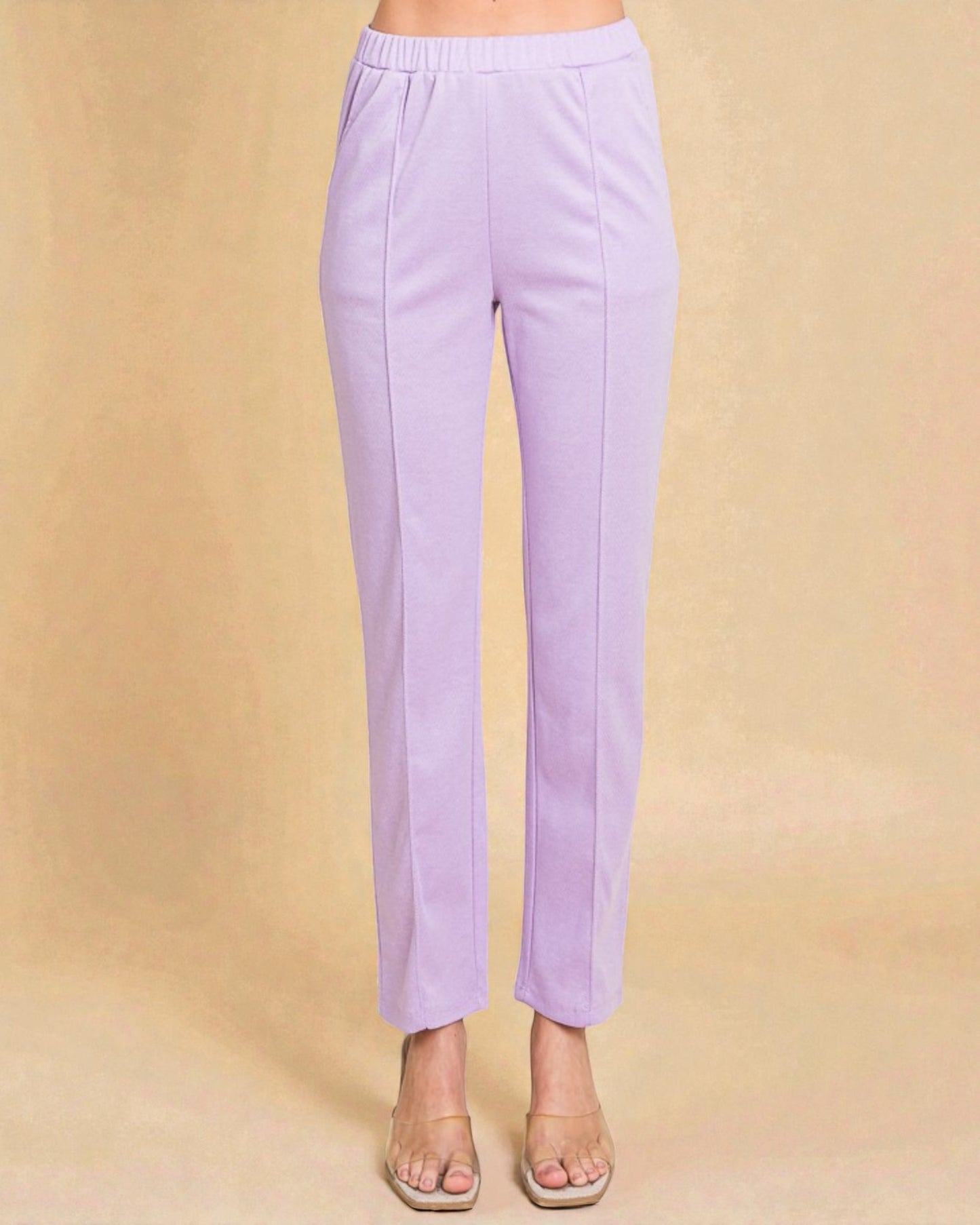 Lavender pants worn by a person on a beige background