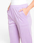 Lilac purple sweatpants with an elastic waistband and side pockets, shown on a mannequin with hands in pockets against a white background.