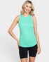 Woman wearing a green tank top and black shorts on a white background