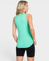 Woman wearing a green sleeveless top and black shorts on a light gray background