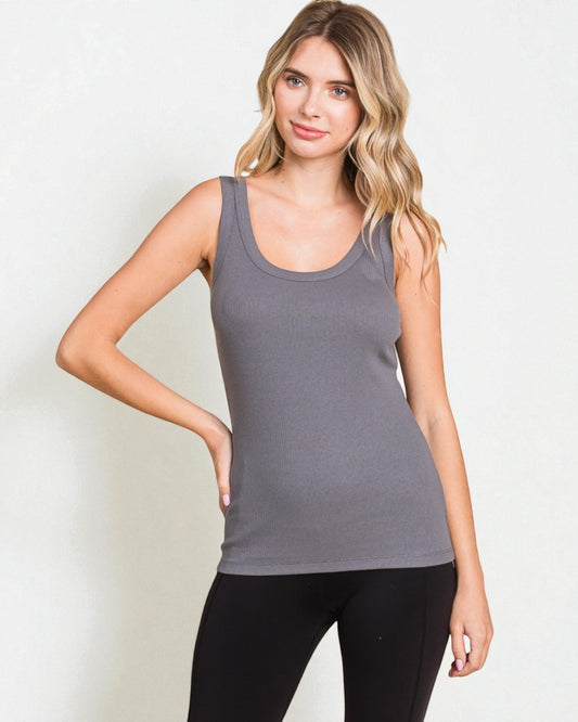Woman wearing a gray tank top and black leggings on a white background