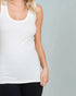 Person wearing a white tank top against a gray background