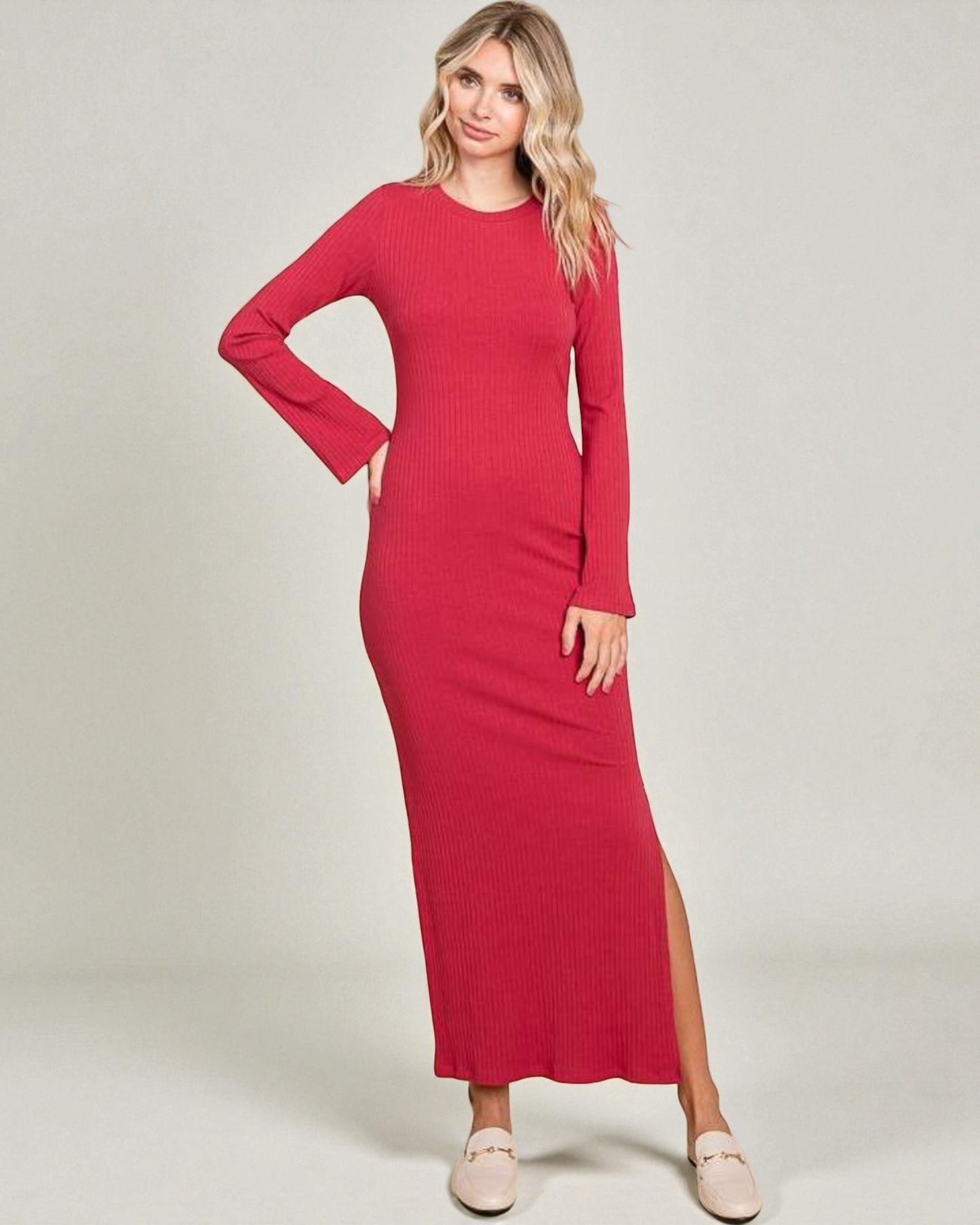 Woman wearing a red dress with a slit on a plain background