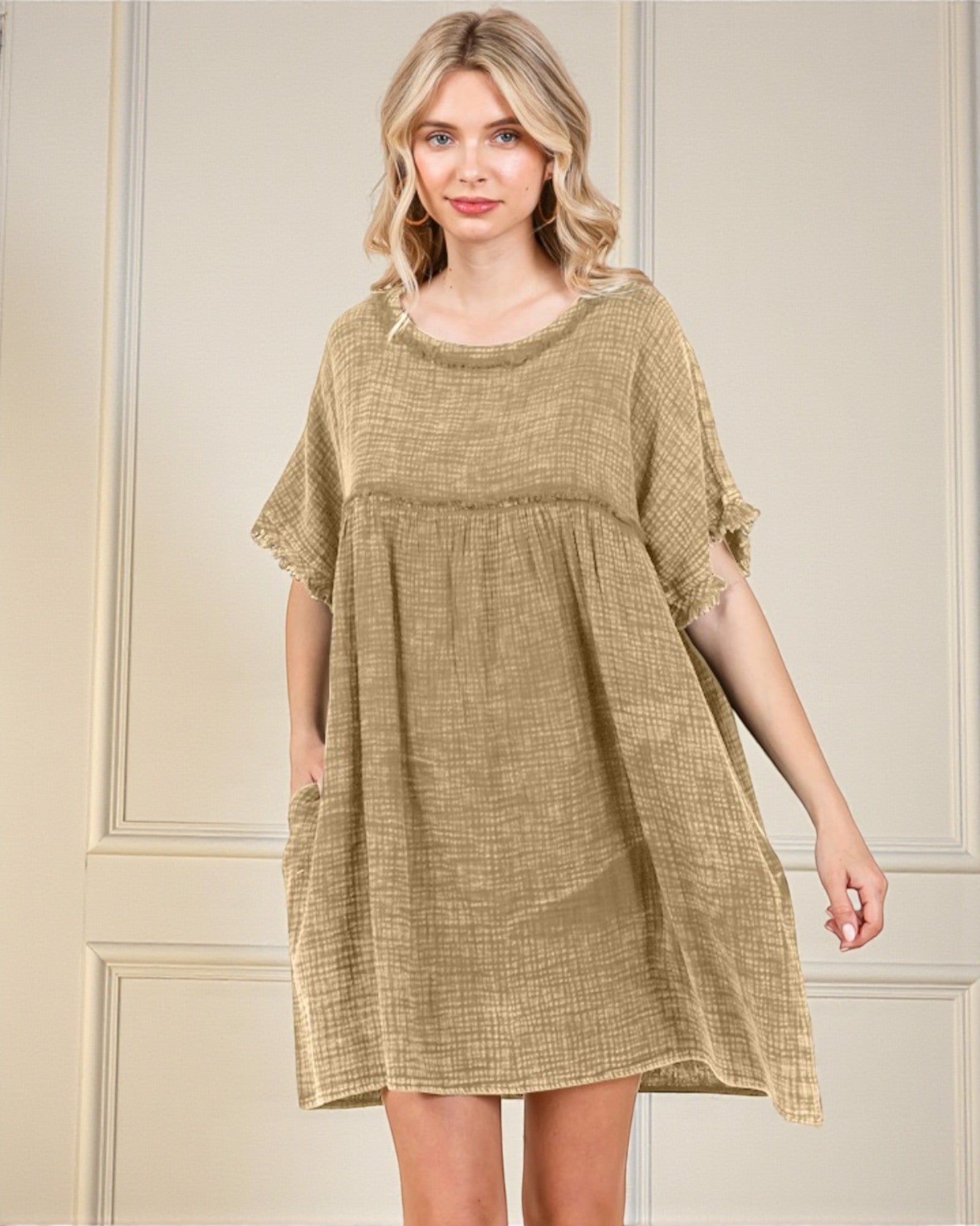 Woman wearing a beige dress against a neutral background