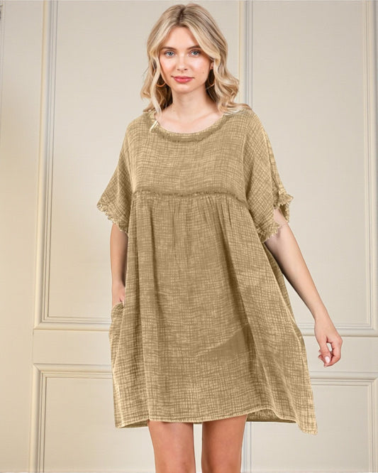 Woman wearing a beige dress against a neutral background