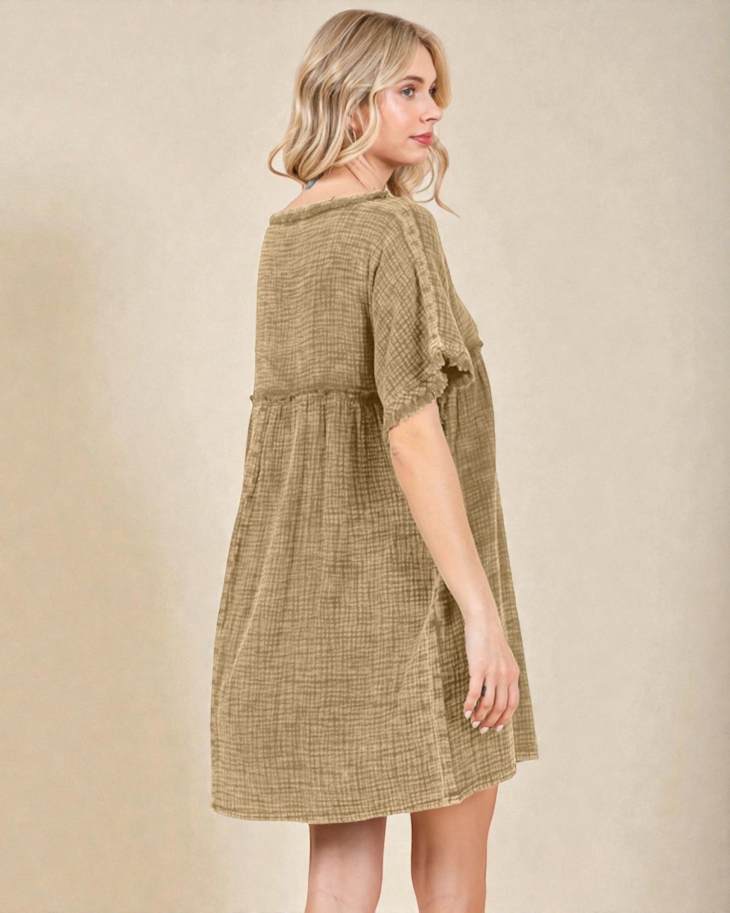 Woman wearing a green checkered dress against a beige background