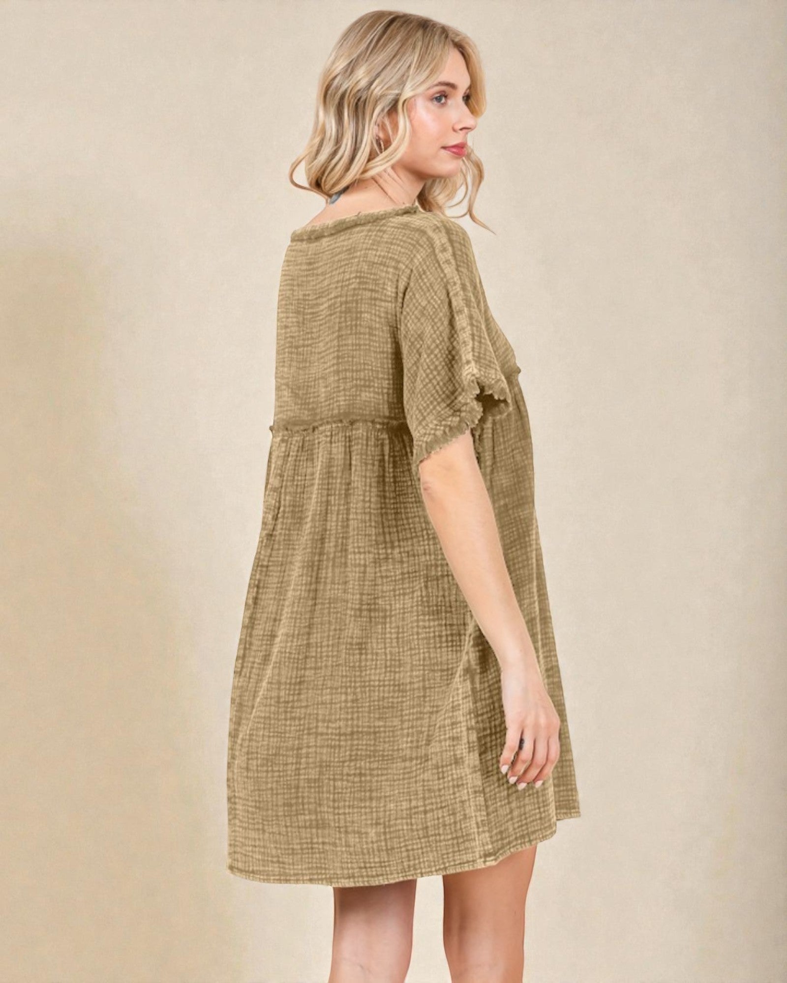 Woman wearing a green checkered dress against a beige background