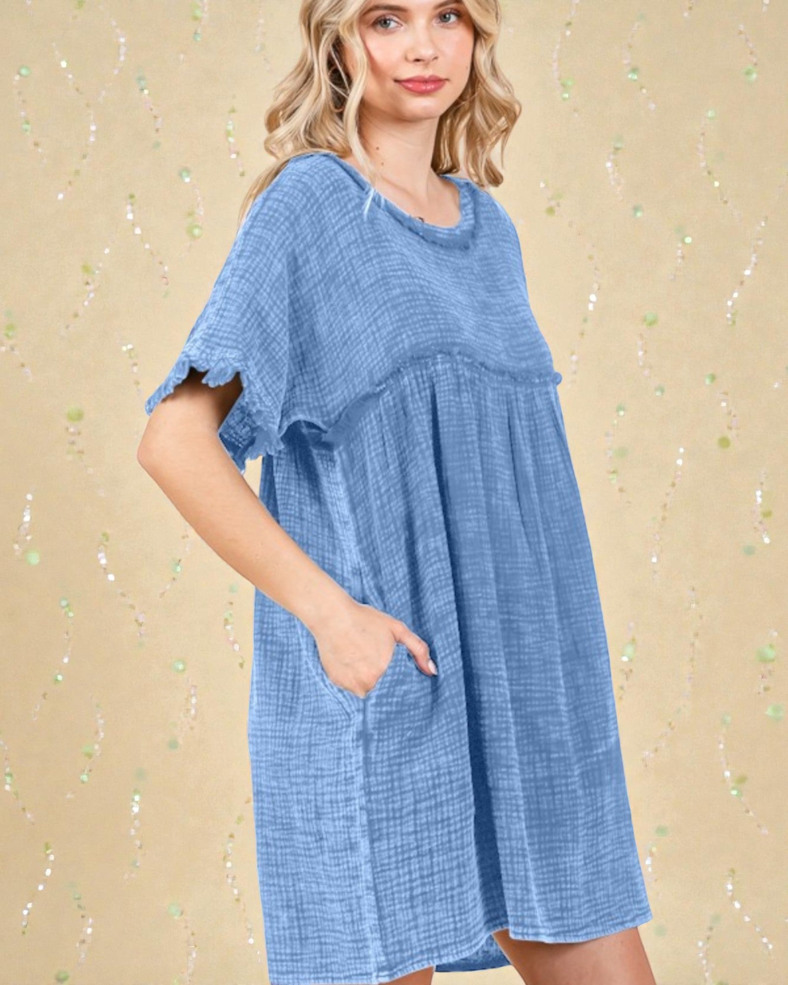 Woman wearing a blue dress against a beige background