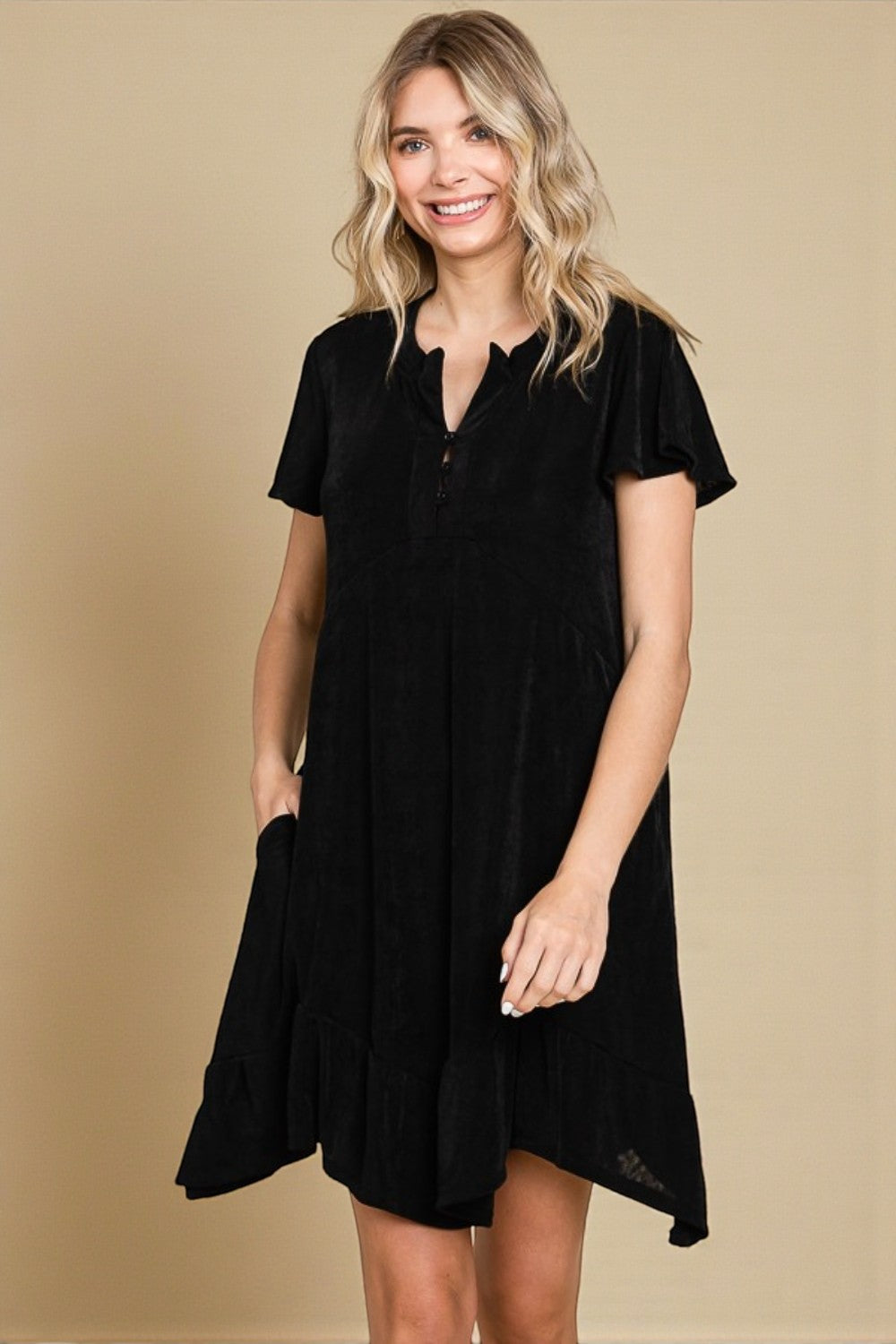 Woman wearing a black dress against a beige background