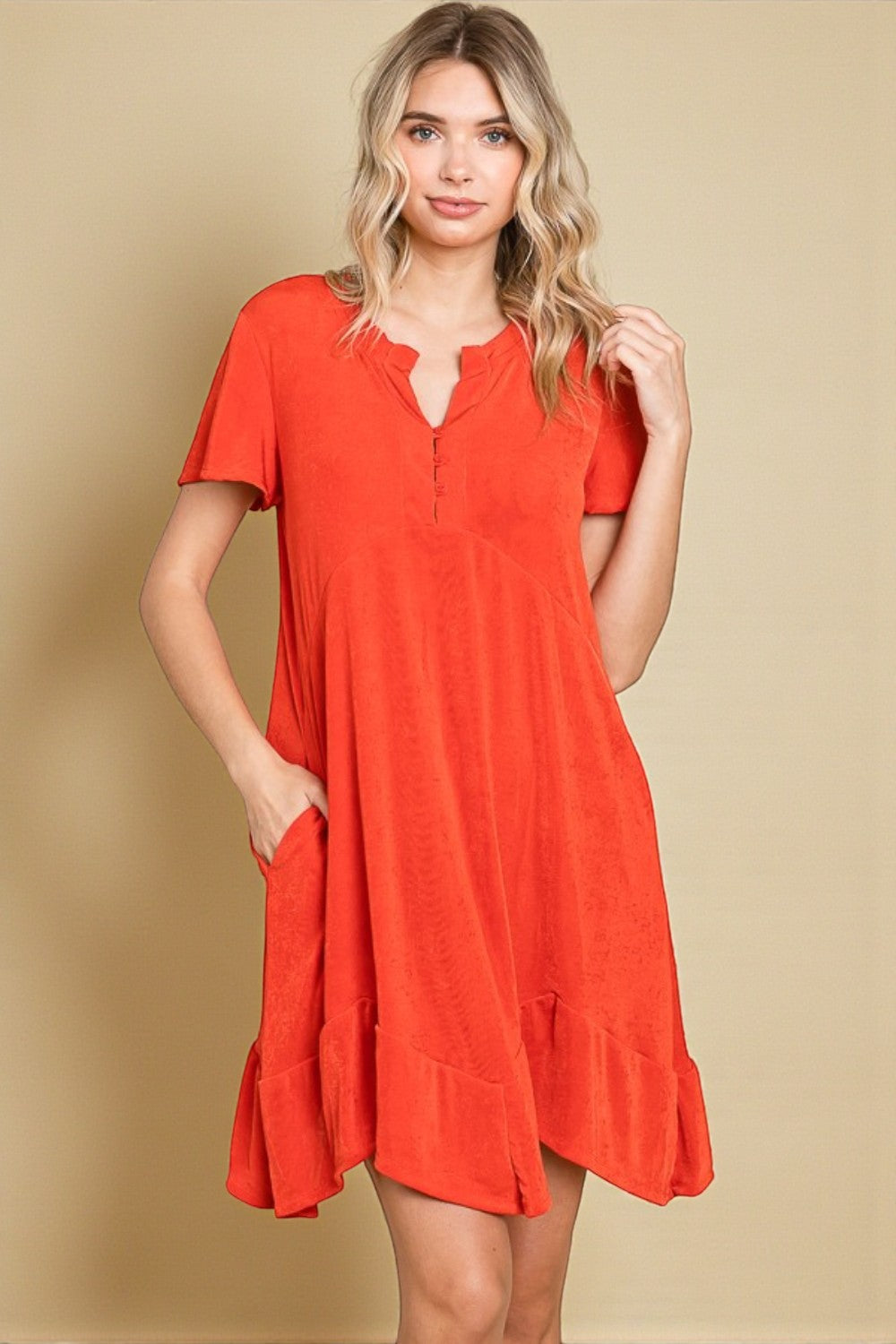 Woman wearing a red dress against a beige background