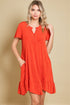 Woman wearing a red dress against a beige background
