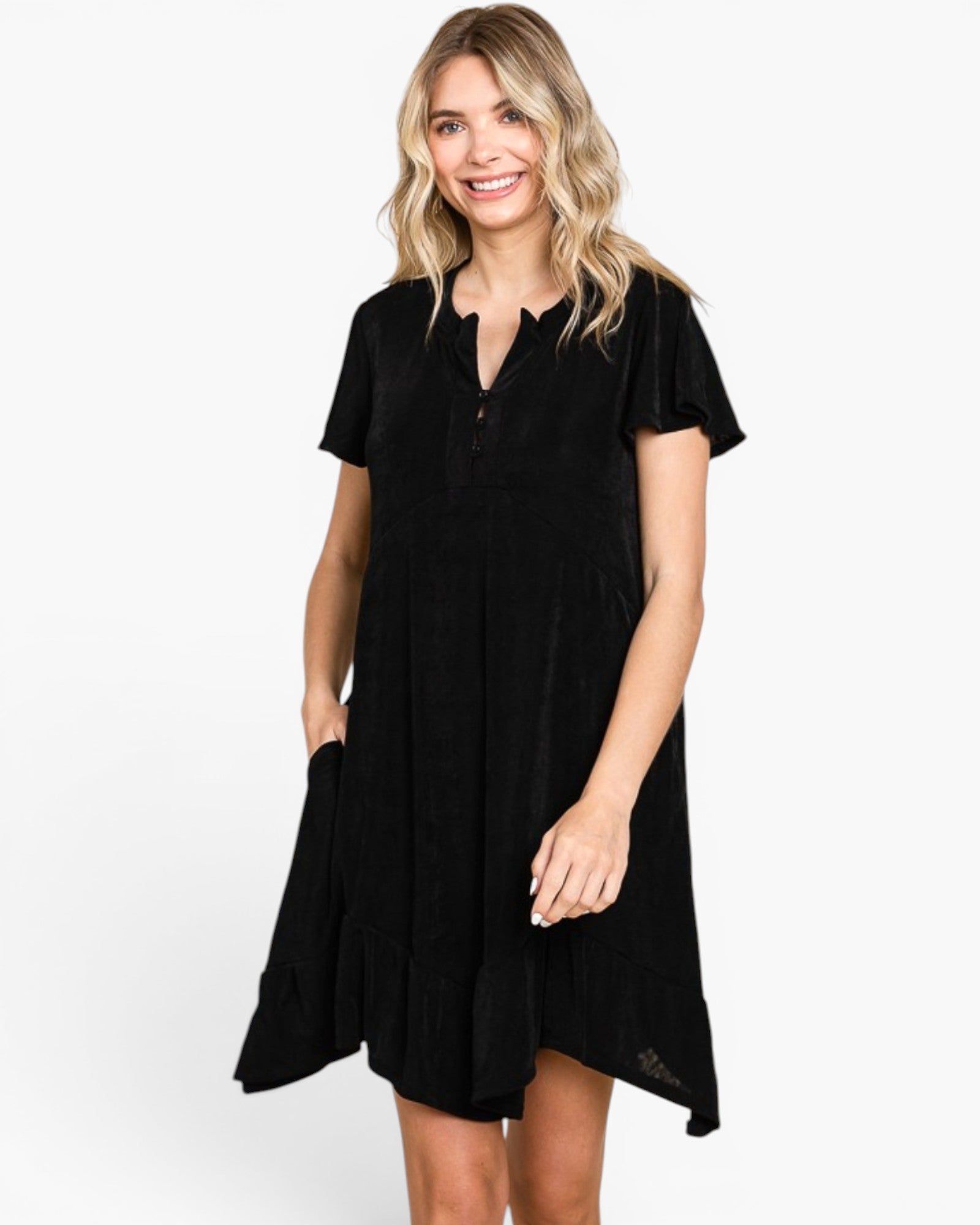 A woman modeling a short-sleeve black dress with a split neckline and button detail, photographed against a plain light gray studio background.