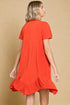 Woman wearing a red dress with ruffled hem on a beige background