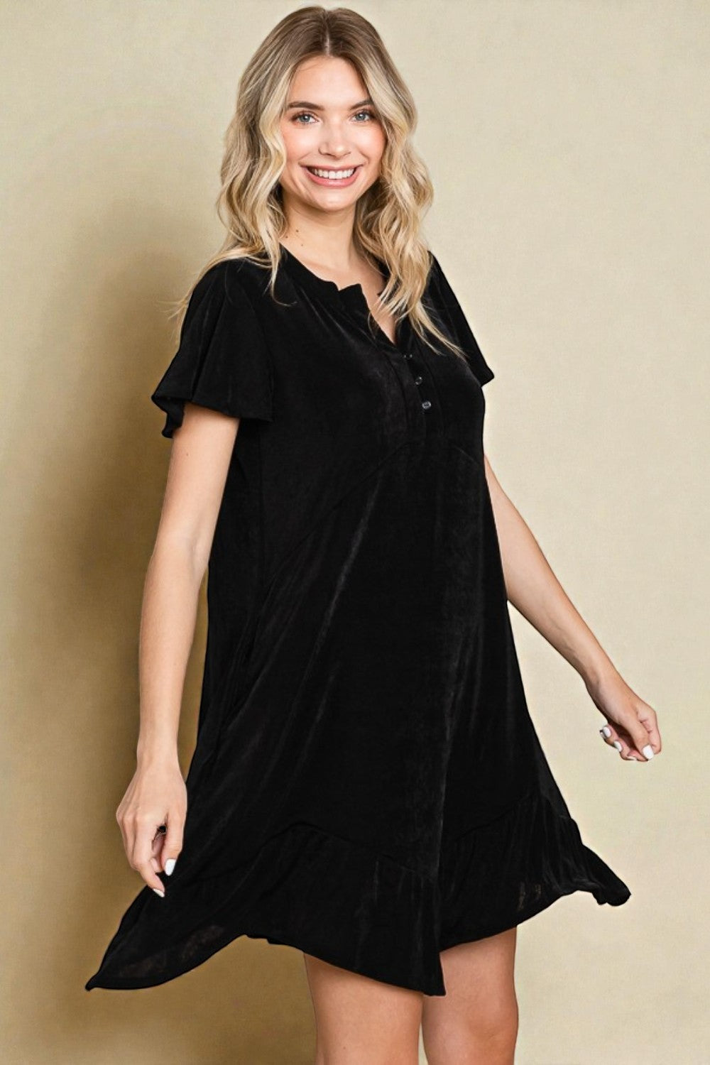 Woman wearing a black dress against a beige background