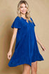 Woman wearing a blue dress against a beige background