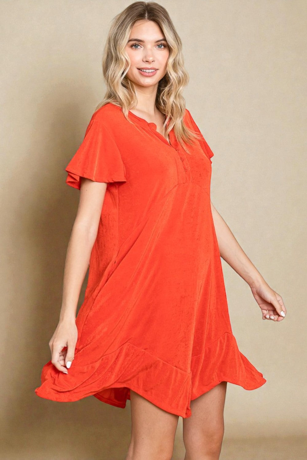 Woman wearing a red dress against a beige background