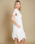 Woman wearing a white dress against a beige background