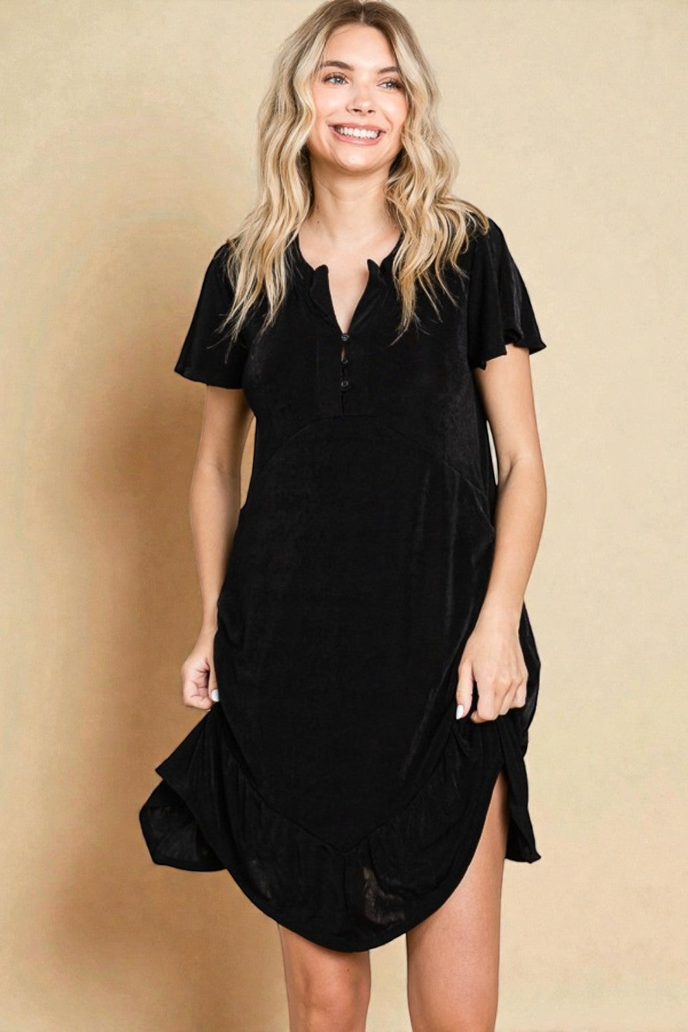 Woman wearing a black dress against a beige background