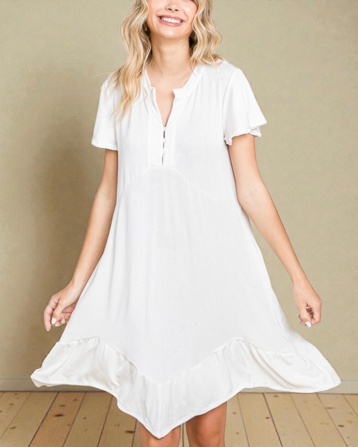 Woman wearing a white dress against a beige wall