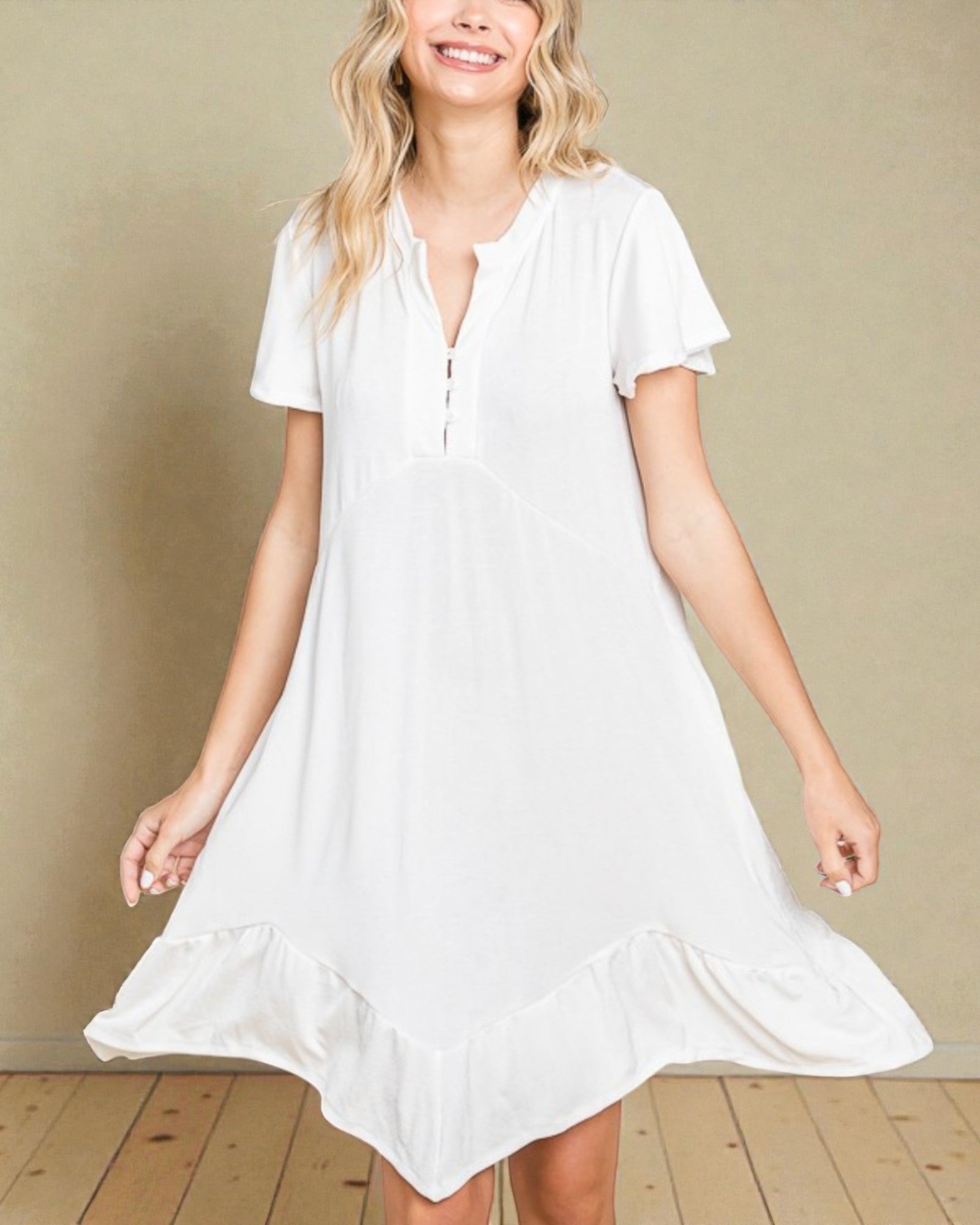 Woman wearing a white dress against a beige wall