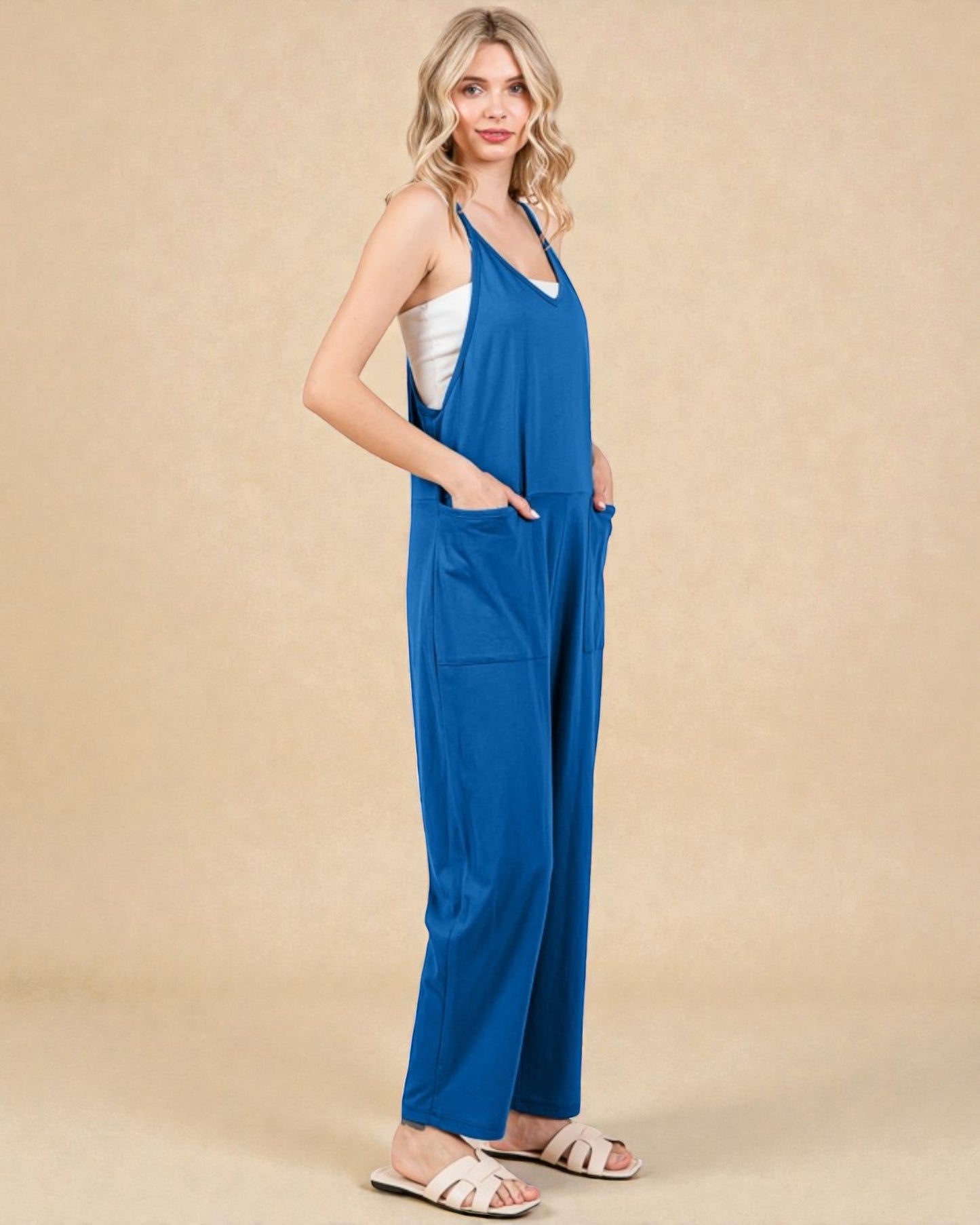 Woman wearing a blue jumpsuit on a beige background