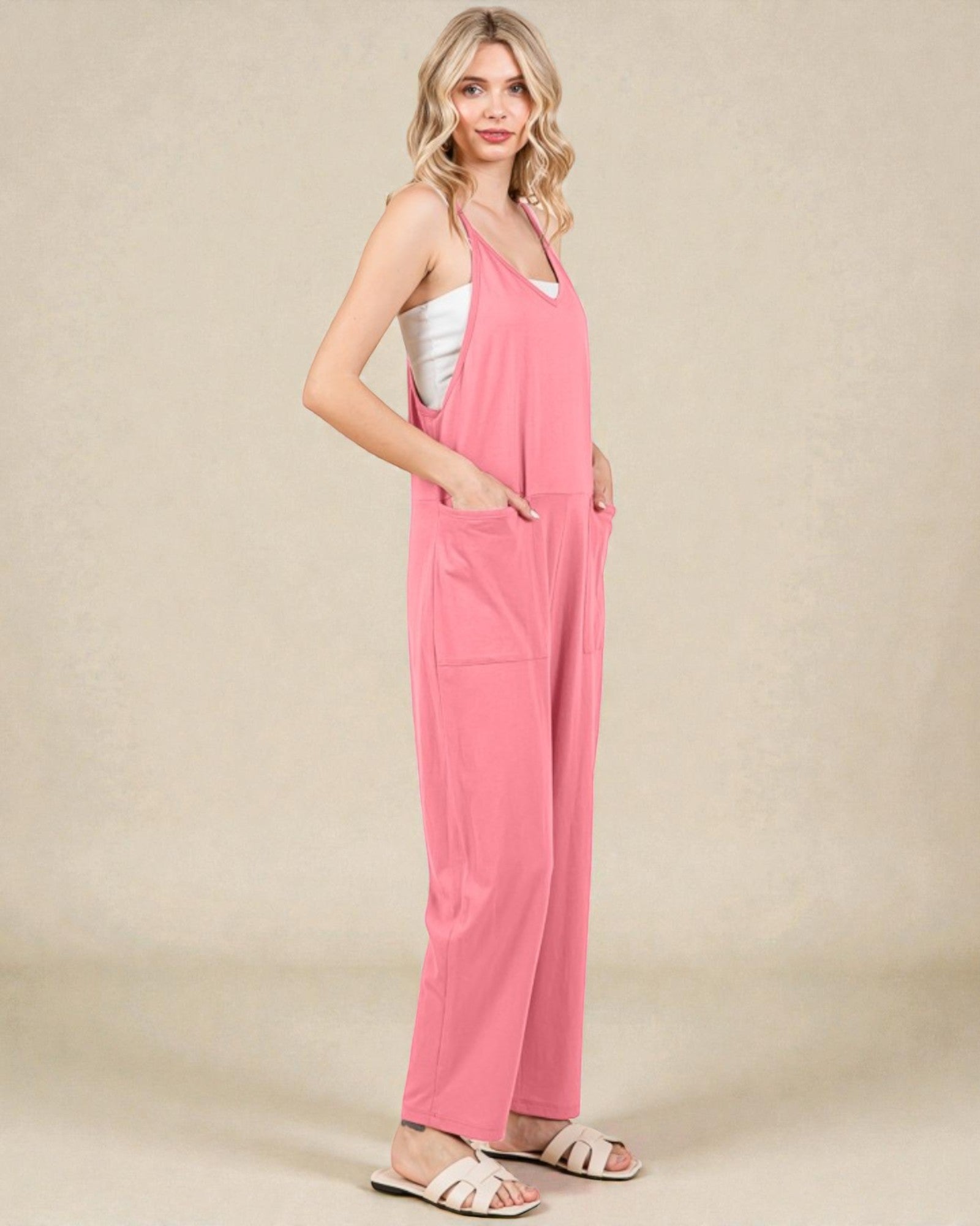 Woman wearing a pink jumpsuit on a beige background