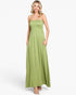 A woman modeling a sleeveless, smocked, and floor-length lime green maxi dress with side pockets, set against a plain white studio background.