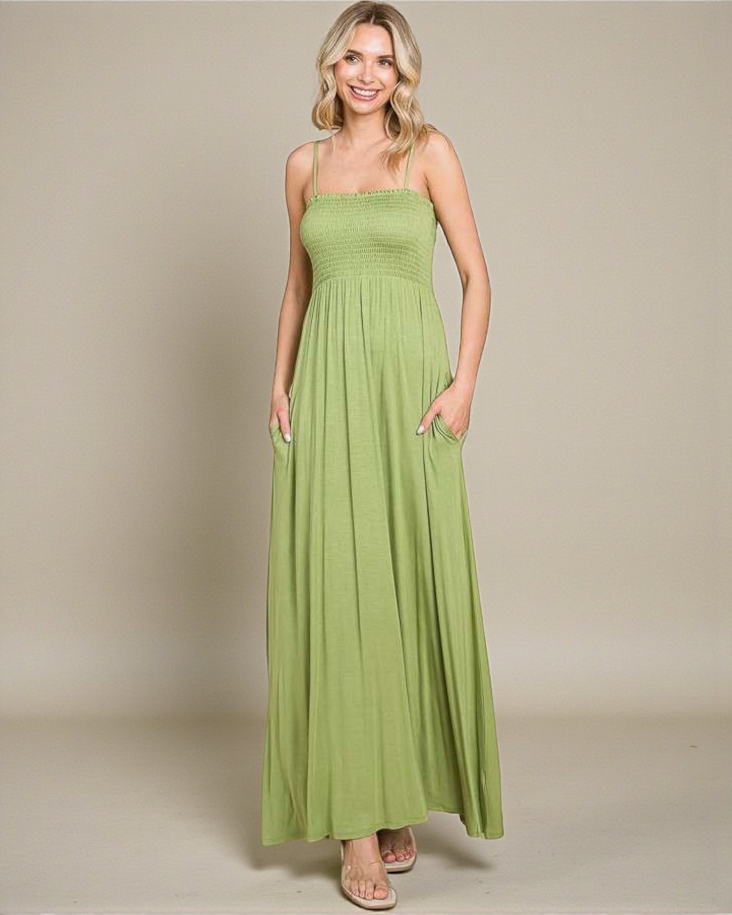 Woman wearing a green maxi dress against a plain background