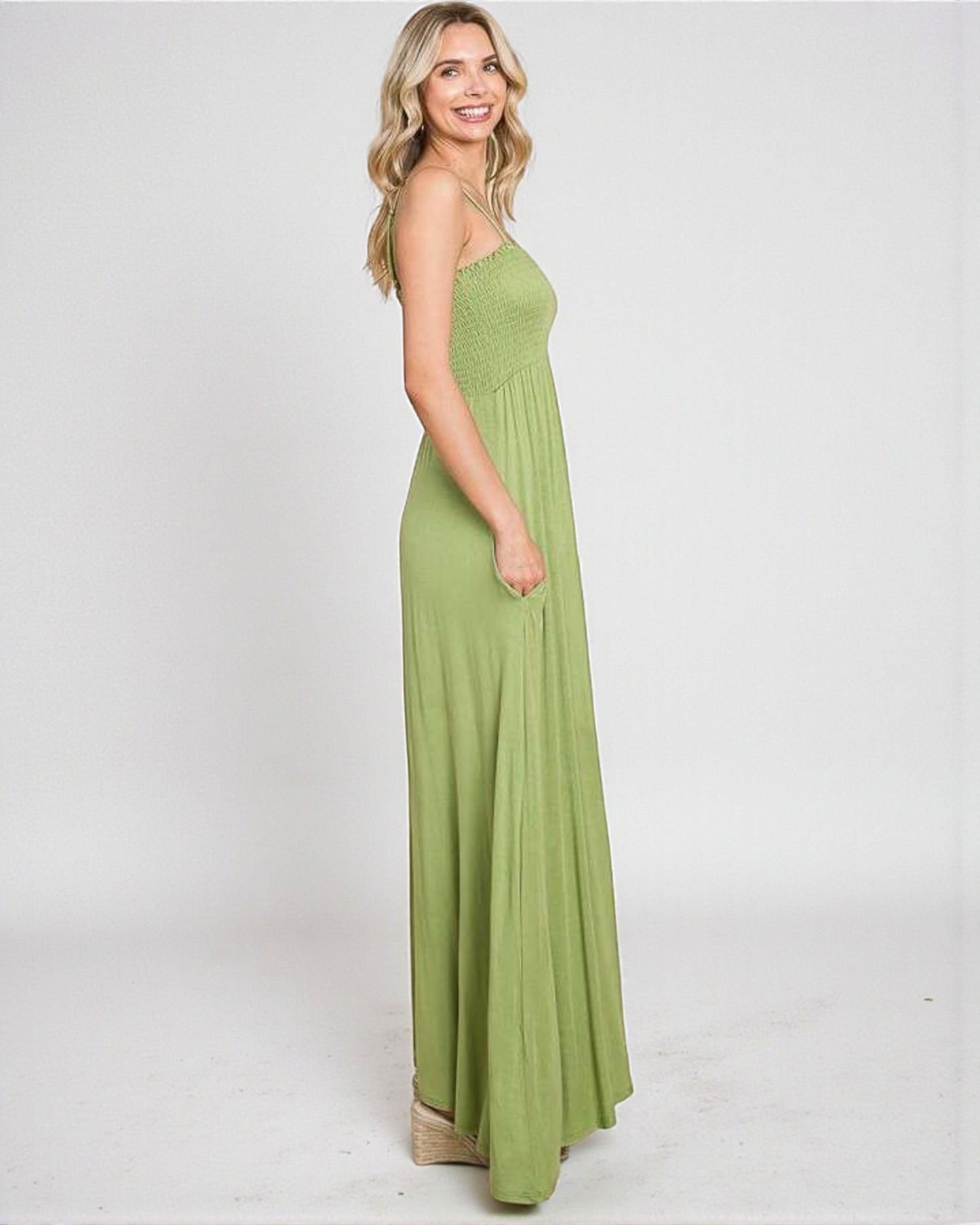 Woman wearing a green maxi dress on a white background