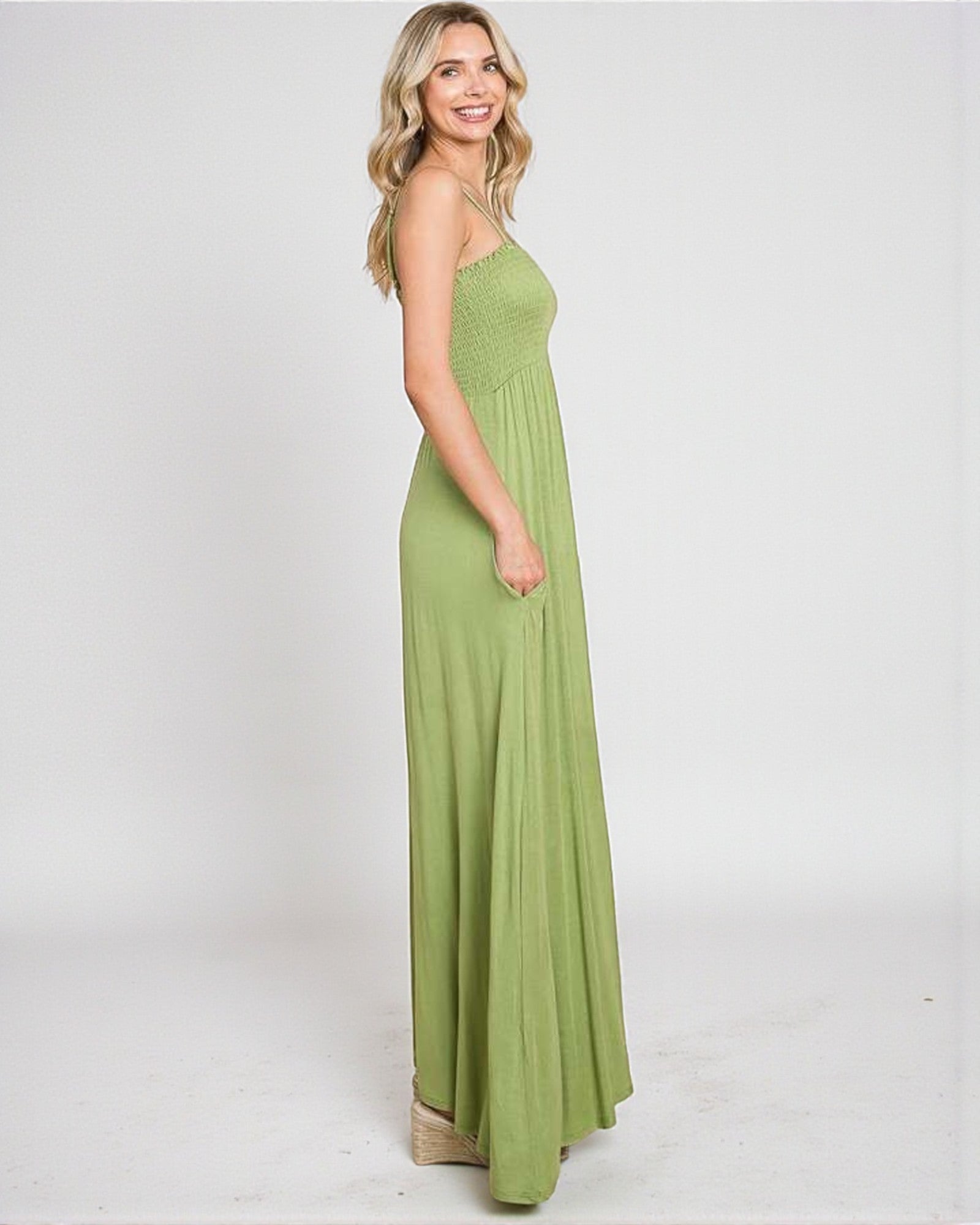 Woman wearing a green maxi dress on a white background