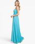 A woman modeling a sleeveless, floor-length turquoise blue dress against a plain white studio background.