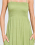 Green dress worn by a person on a plain background