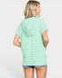 A woman shown from the back wearing a light green and white horizontally striped short-sleeve hooded t-shirt and denim shorts against a light gray studio background.