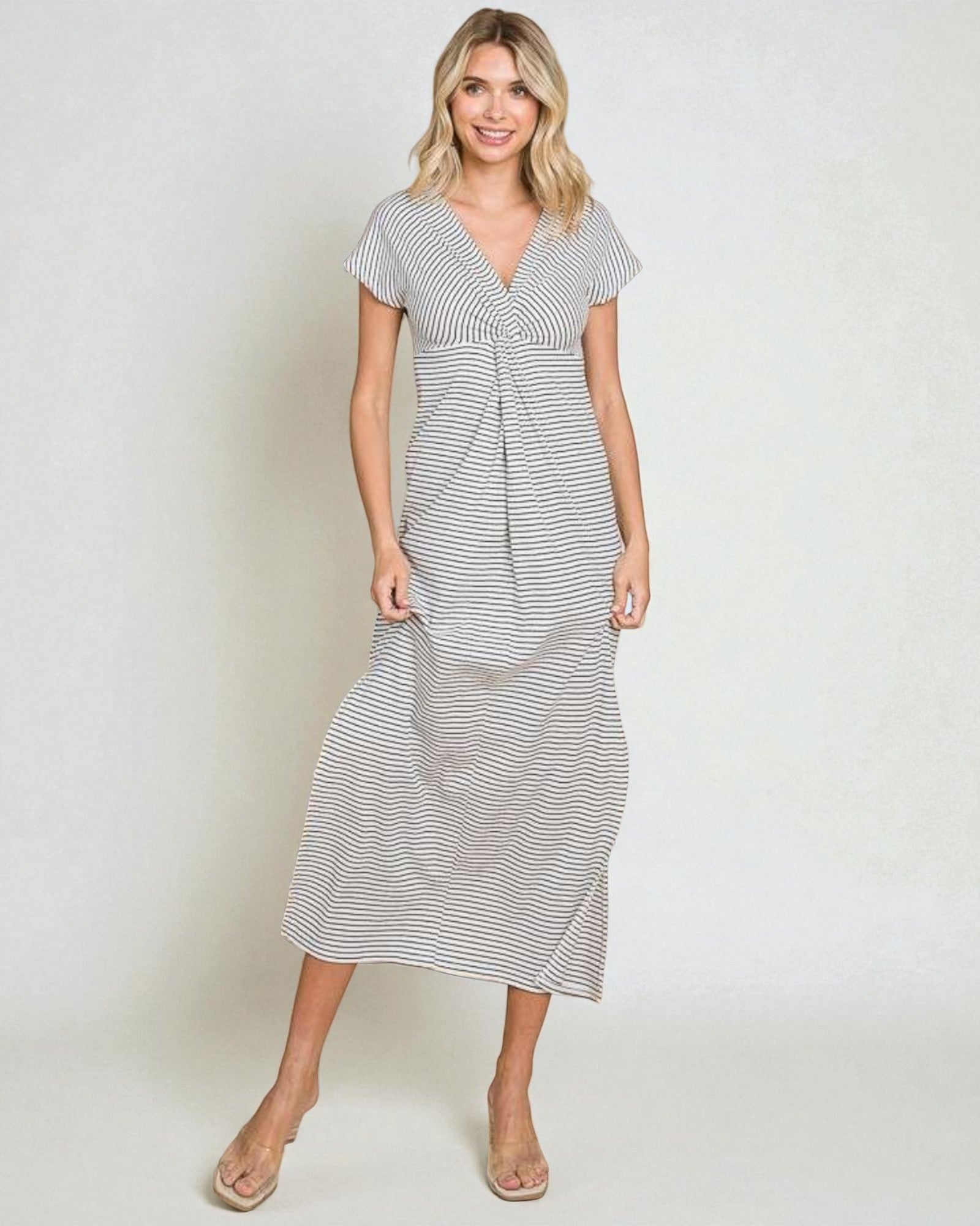 Woman wearing a striped dress on a plain background