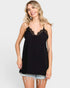 Woman wearing a black lace-trimmed camisole against a plain background