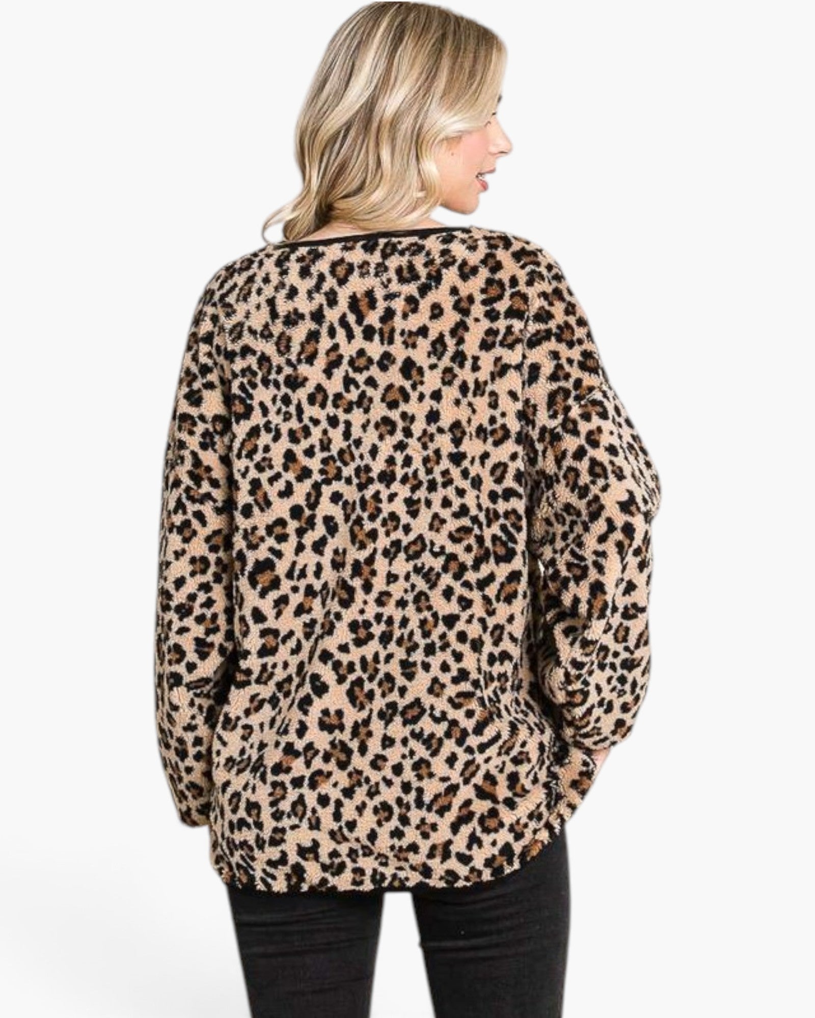 A woman shown from the back wearing a beige leopard-print fleece sweater with black pants, photographed against a plain white studio background.